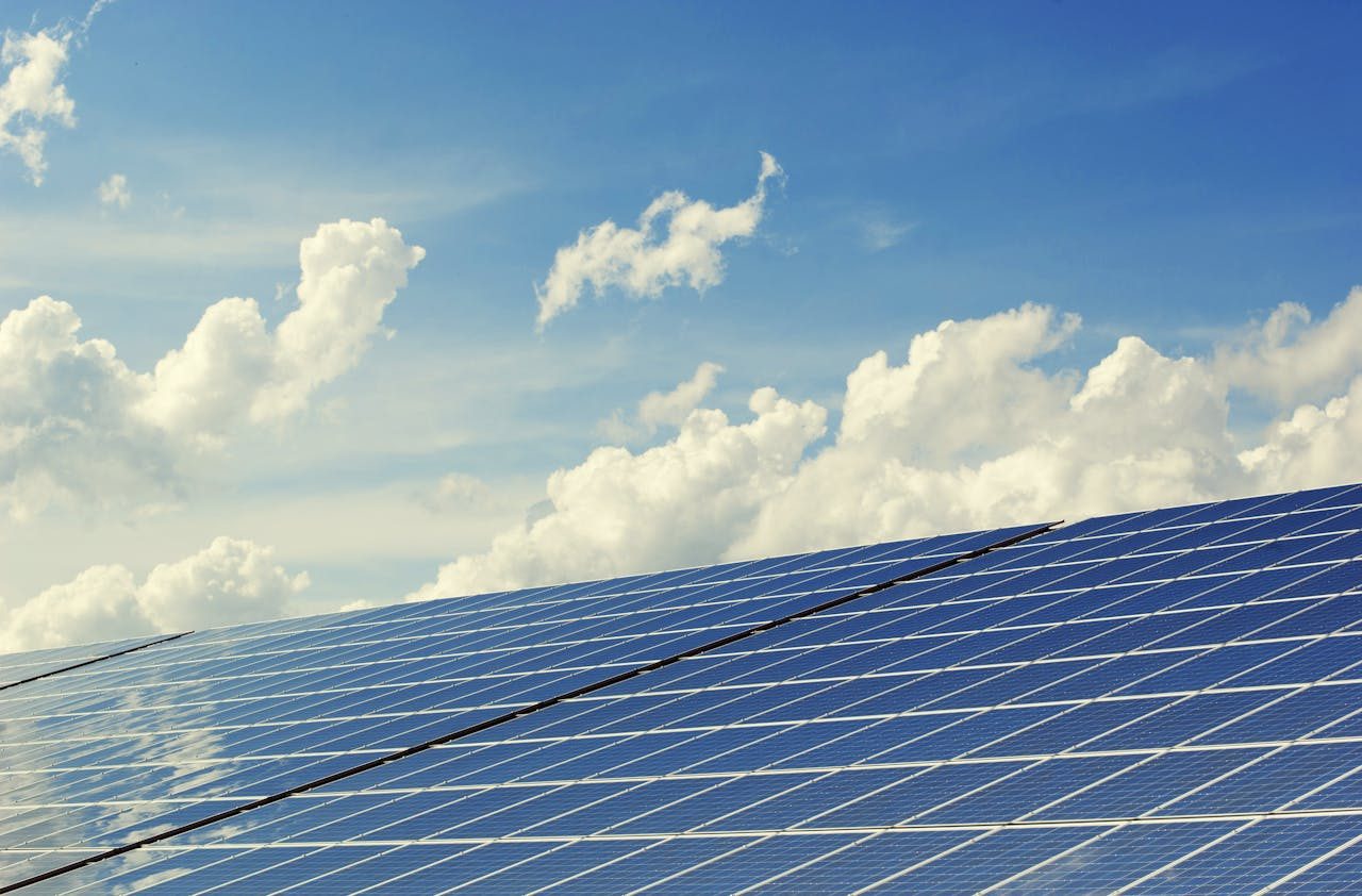 Solarmodule vor blauem Himmel mit Wolken