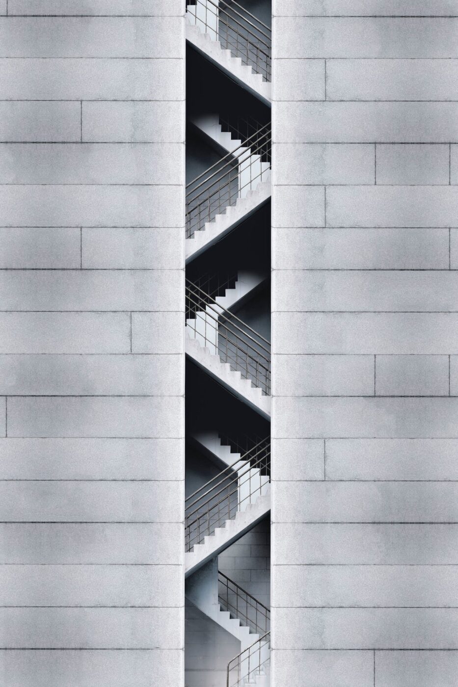 Offener Treppenturm in einer hellen Betonfassade