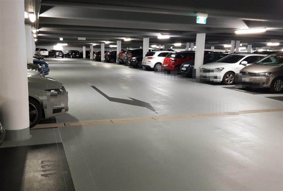 Dieselbe Tiefgarage nach der Sanierung: helle Beschichtung mit neuer Markierung